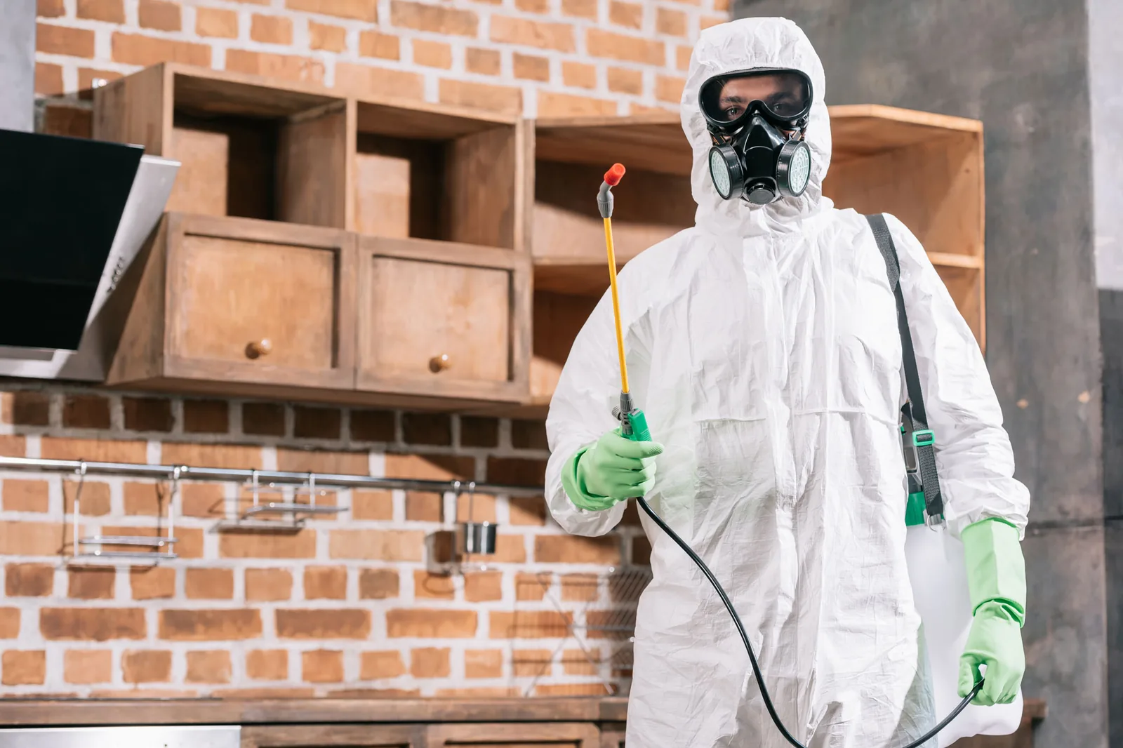 Ridtechs pest control technician in protective gear preparing to treat a Las Vegas home